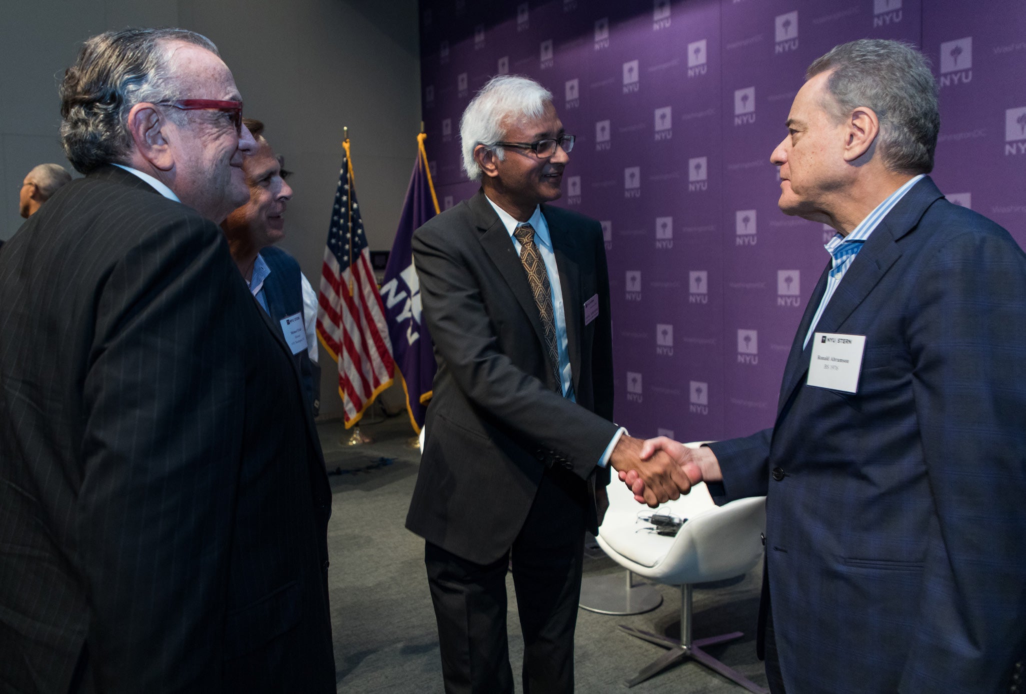 Photo of Dean Raghu Sundaram shaking hands with an alumnus