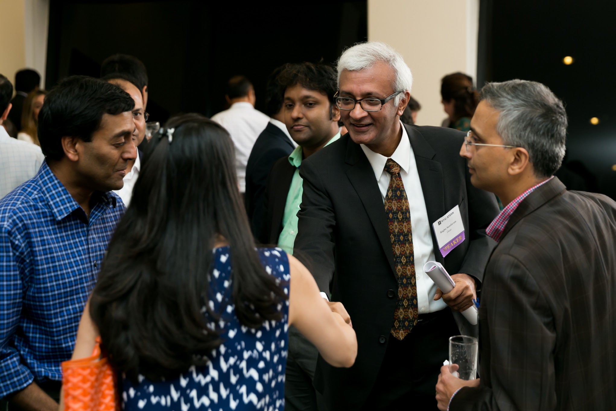 Dean Sundaram shaking hands with an alumna