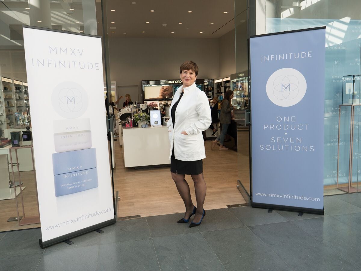 Mirela Mitan stands in front of MMXV Infinitude signs