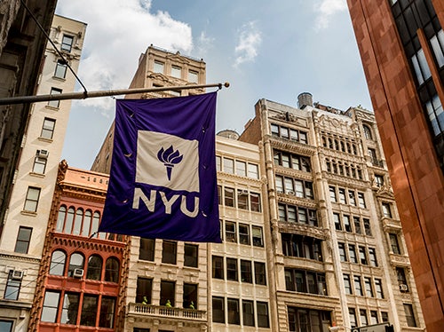 NYU flag against downtown skyline