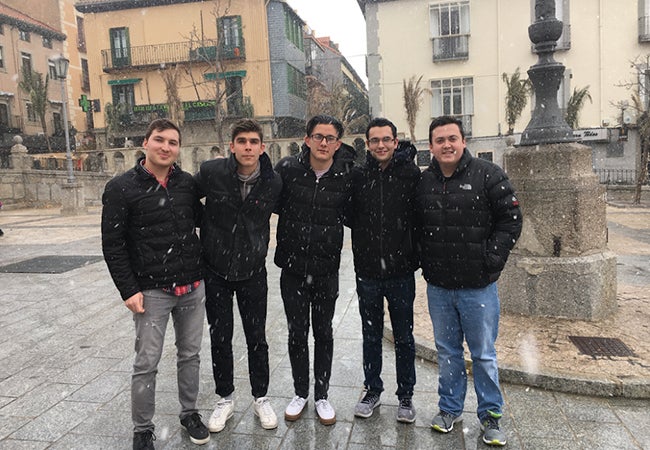 Business student Kristian poses with new friends outside in freezing rain while studying abroad in Spain. 