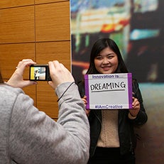 Student holding up sign reading "Innovation is dreaming"