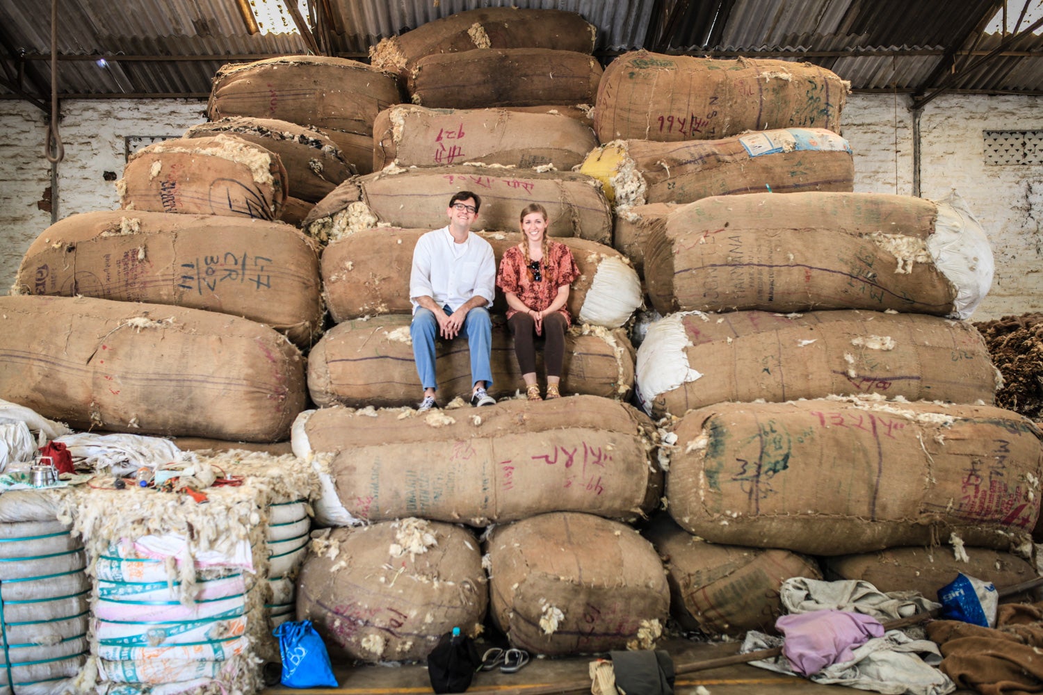 Photo of Van Bergen and Nest program team member Sara Otto sitting on piles of wool