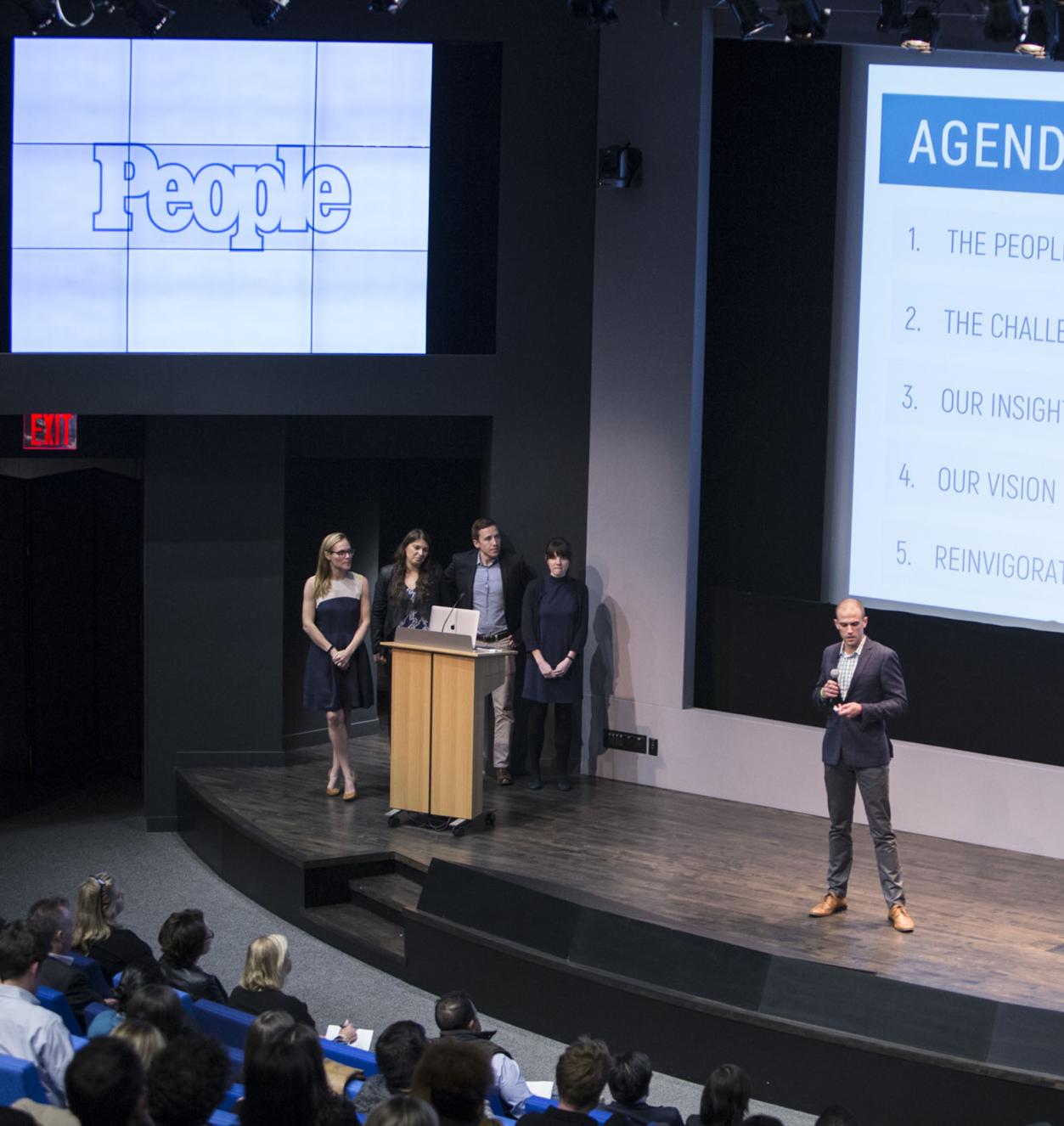 Four students presenting on a stage 