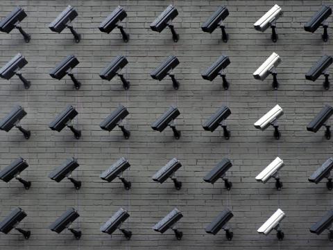 A brick wall filled with security cameras