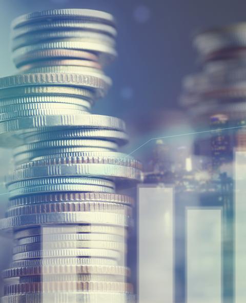 Double exposure of city and graph on rows of coins for finance and banking concept