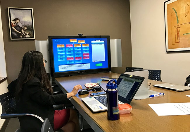 A business school student at IESE in Barcelona looks at a computer screen while participating in a group exercise. 