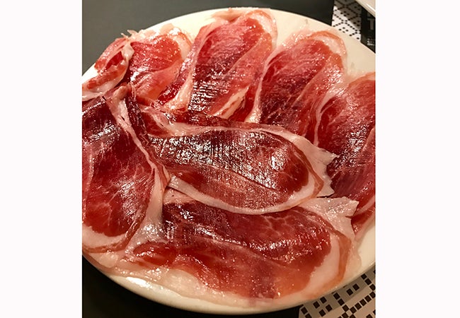 A plate of jamon, or cured ham, is arranged on a plate during a meal in Barcelona. 