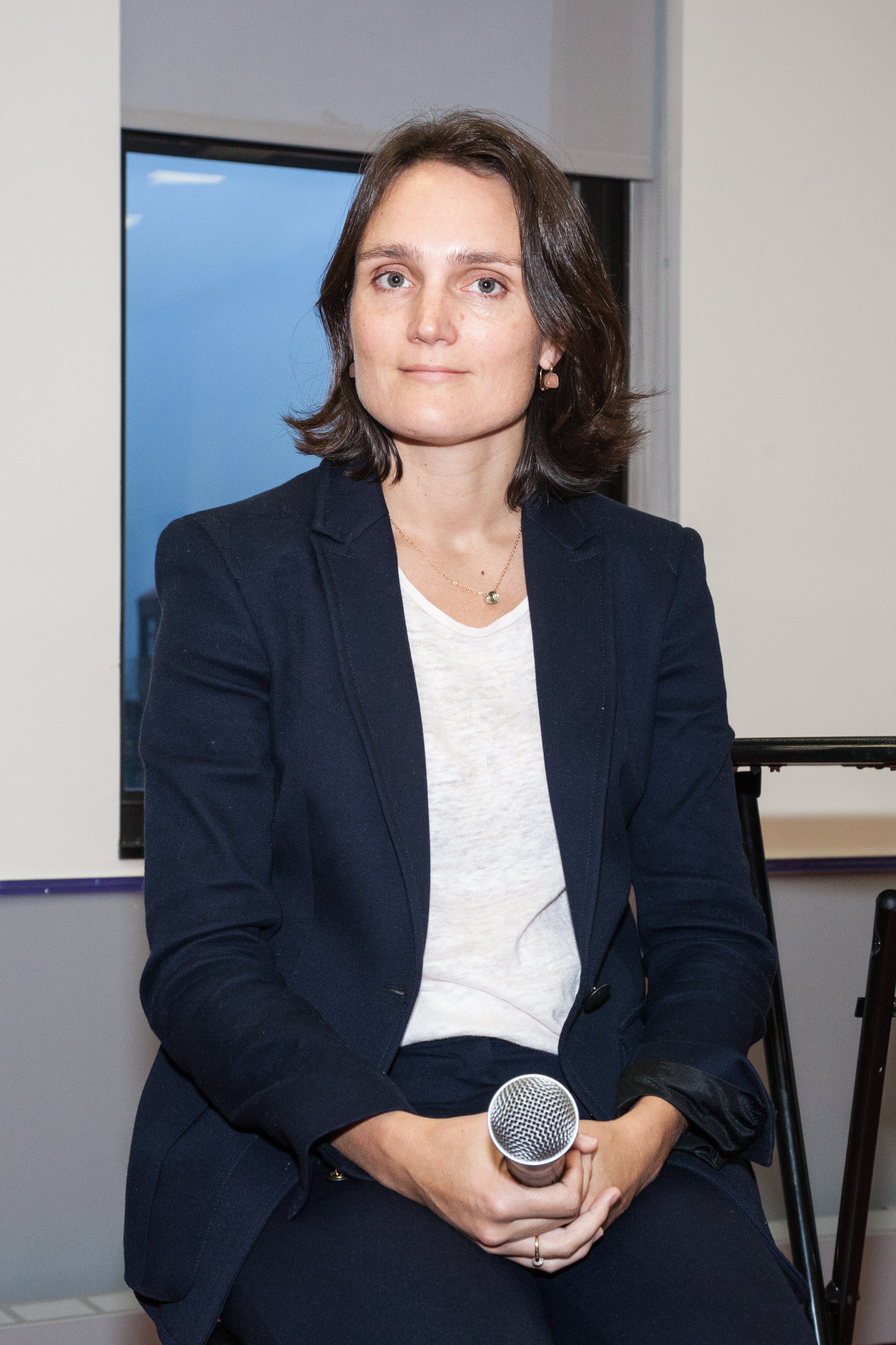 Photo of Ann Van Riel holding a microphone 