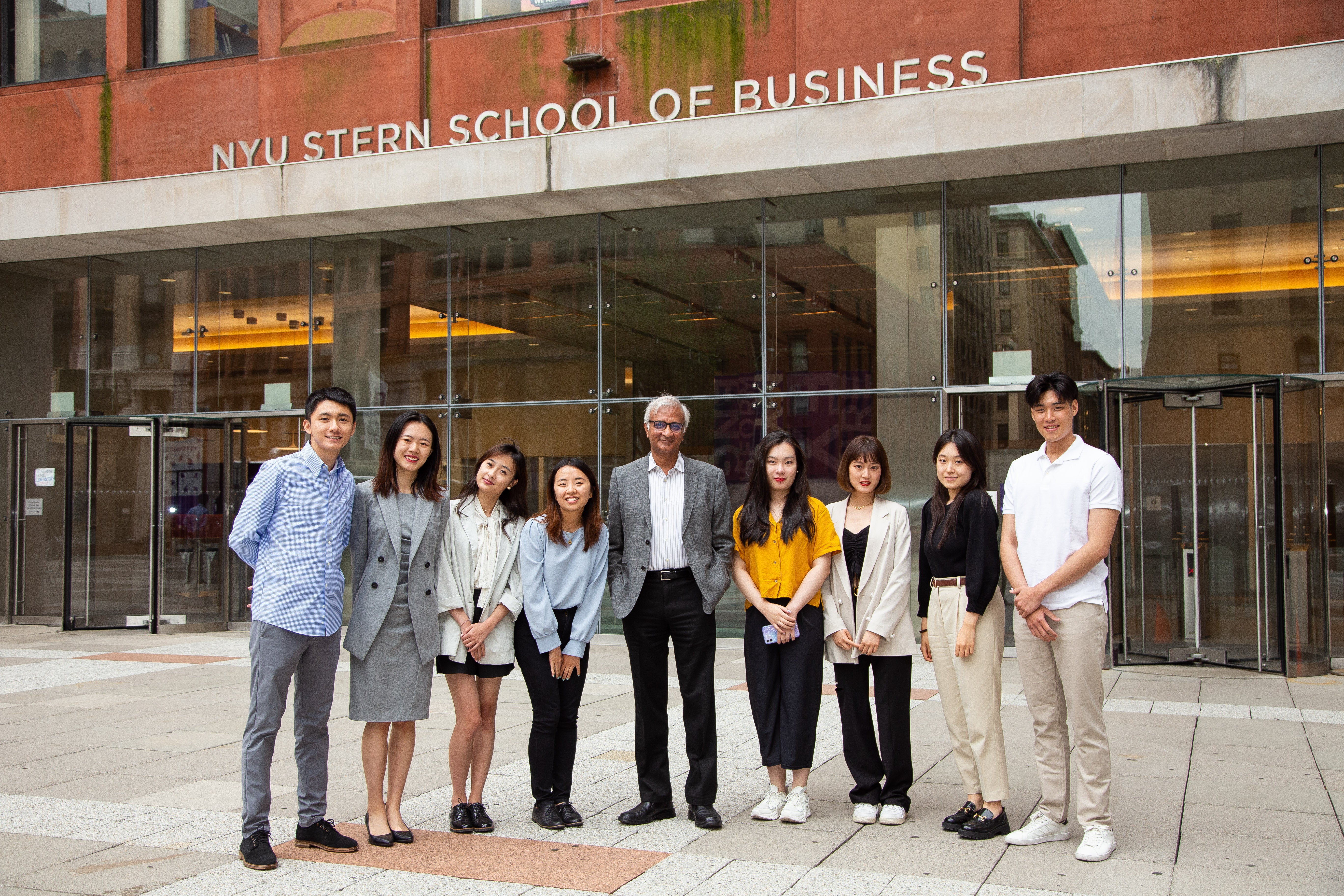 Dean Raghu Sundaram poses with students outside after orientation