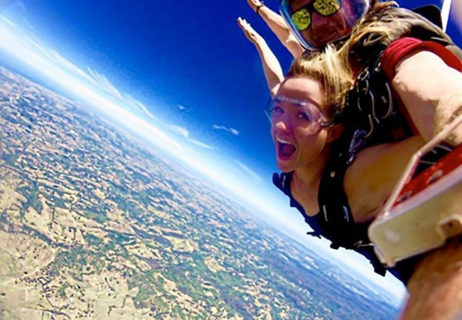 MBA student Cara Witt-Landefeld looks at the camera while skydiving with a partner in Australia. 