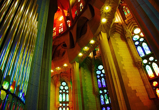 A rainbow of colors emanate from stained glass windows inside La Sagrada Familia Basilica.