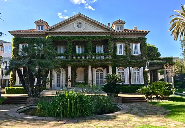 A two-story building is covered in ivy on IESE Business School in Barcelona.