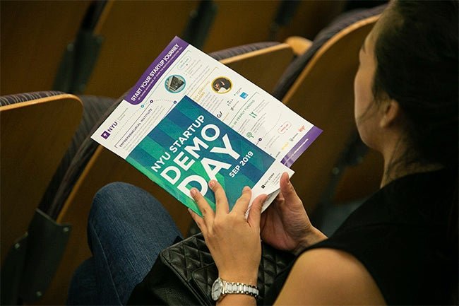 Hands holding demo day pamphlet