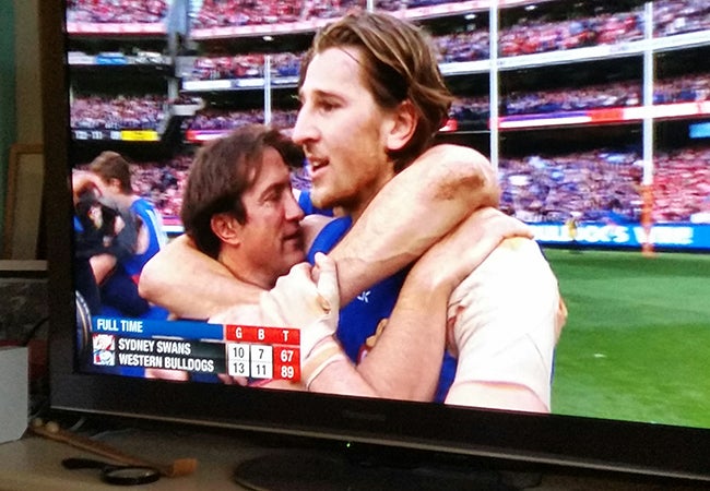 Two Australian football teams compete on television. 