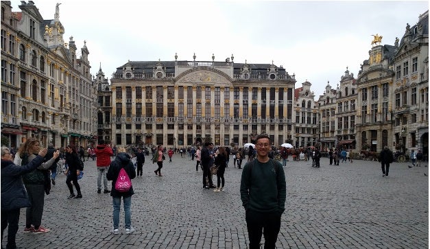 MBA student Dennis Au stands in a city square in Brussels. 
