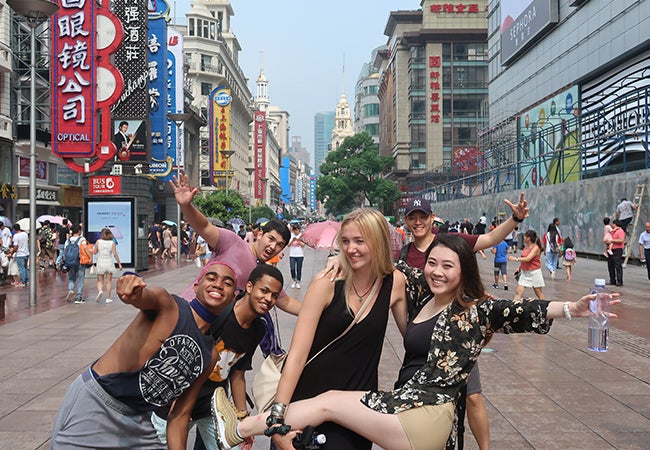 Business student Dimitri Pun poses with friends on a busy street while studying abroad in Shanghai. 