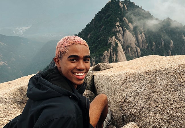 Undergraduate business student Dimitri Pun sits at a scenic overlook during a hike to Haungshan (Yellow Mountain).