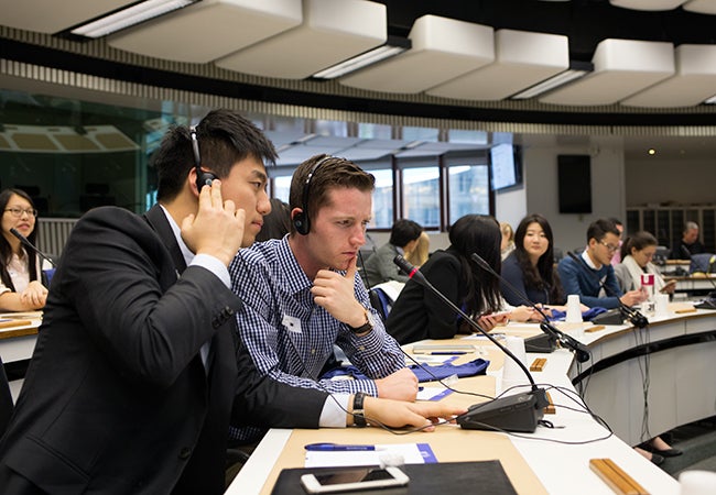 Undergraduate business student Matthew Robinson wears a headset and listens to a translation at the European Commission.