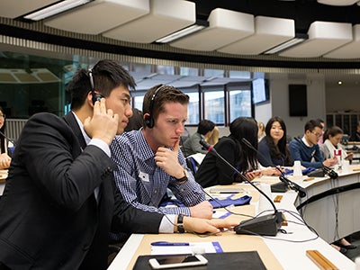 Undergraduate business student Matthew Robinson wears a headset and listens to a translation at the European Commission.
