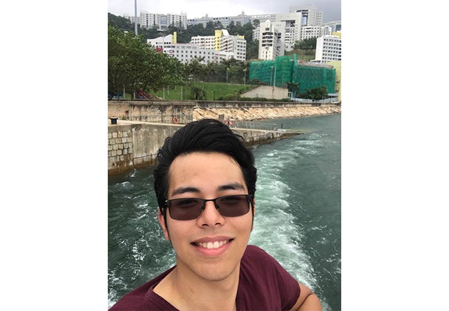 Undergraduate business student Jesse Aguilar takes a selfie during a river cruise while studying abroad in Hong Kong. 