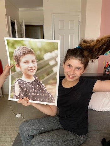 Elana Koenig holding a picture of herself with short hair