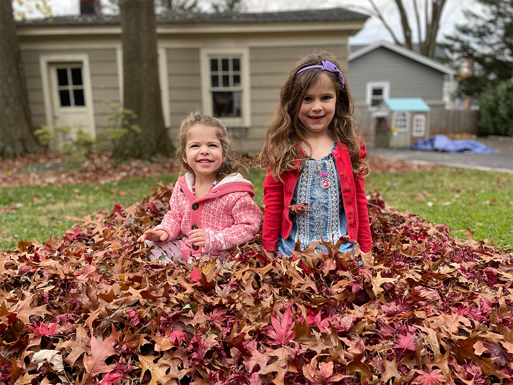 James Kingham's daughters play in a leaf pile outside