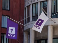 NYU flags outside of the Henry Kaufman Management Center