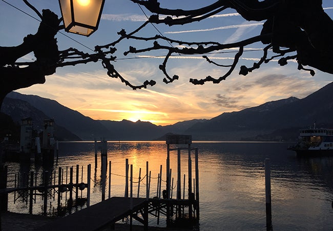 A sunset casts shadows across a dock in the water of Lake Como in Italy. 