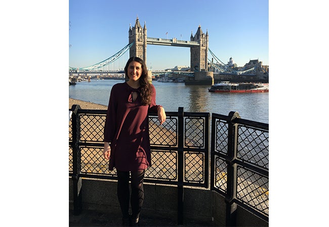 MBA student Alyssa stands in front of the Tower Bridge with the Thames River flowing below.  