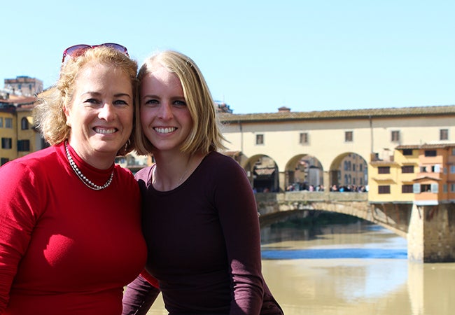 Undergraduate student Michelle Enkerlin poses with her mom in an outdoor city setting. 