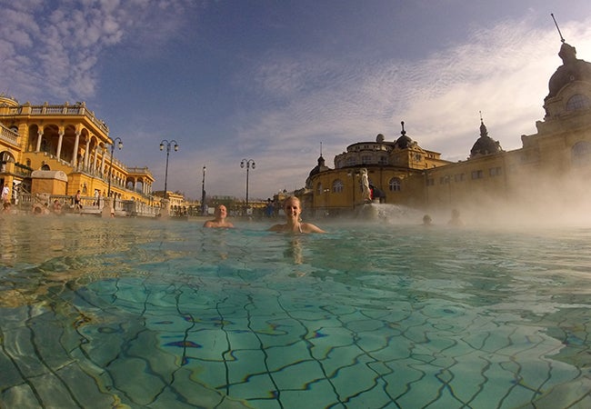 Undergraduate business student Michelle Enkerlin swims in thermal baths as steam rises from the water's surface. 