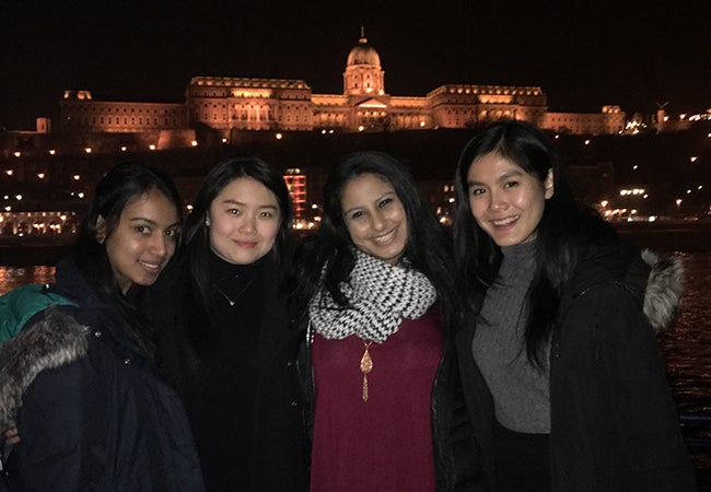 Undergraduate business student Natasha Lim links arms with friends during a nighttime river cruise in Budapest. 