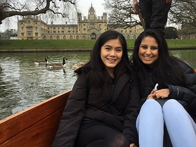 Business student Natasha Lim poses with a friend in front of a lake as several geese swim by. 