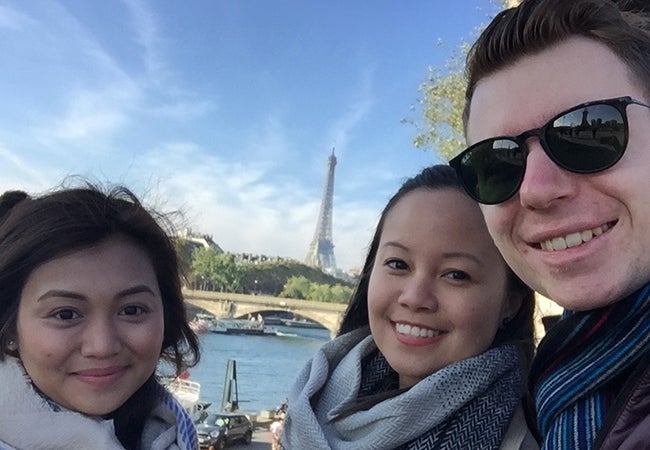 MBA student Kimberly Rodriguez poses with friends before the Eiffel Tower in Paris. 
