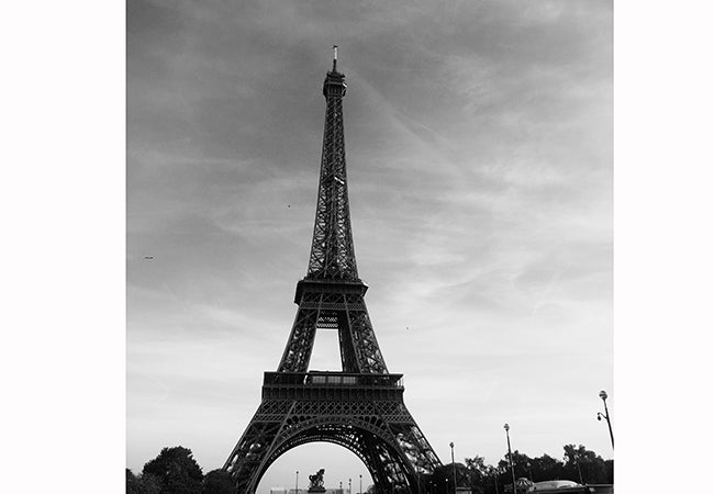 A black-and-white photograph shows the Eiffel Tower on a clear day. 