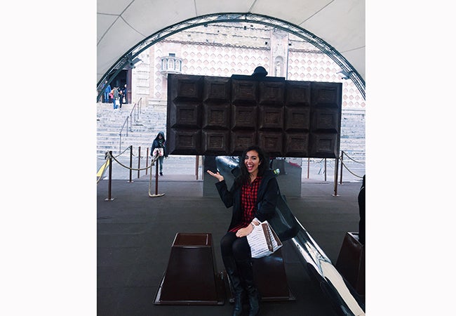 Business student Alexandra Grieco points to a huge chocolate bar on display behind her in Perugia at the famous Euro-Chocolate Festival.