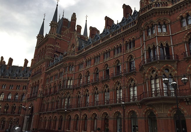 The ornate exterior of St. Pancras railway station is shown on an overcast day in central London.