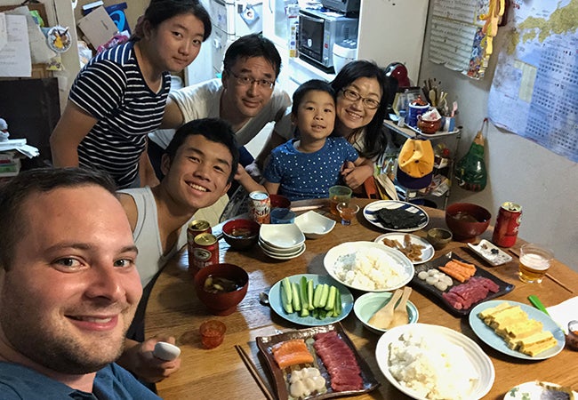 Ryan takes a selfie with five members of his host family around the kitchen table in their home before dinner.