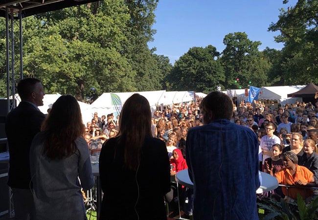 MBA student Sarah Turk speaks to a crowd from an outdoor stage. 