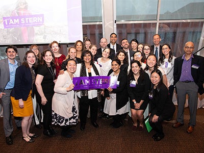 The Undergraduate College team poses with Dean Menon holding an I am Stern sign