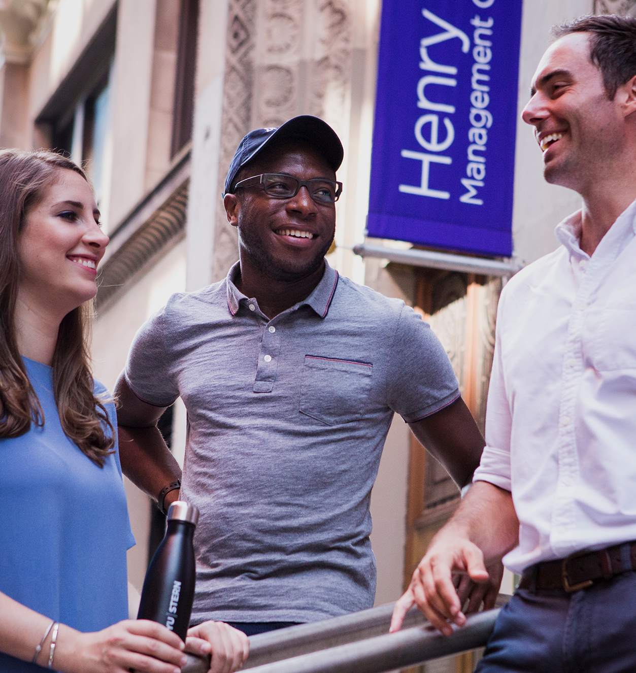 Three people standing in front of the school building