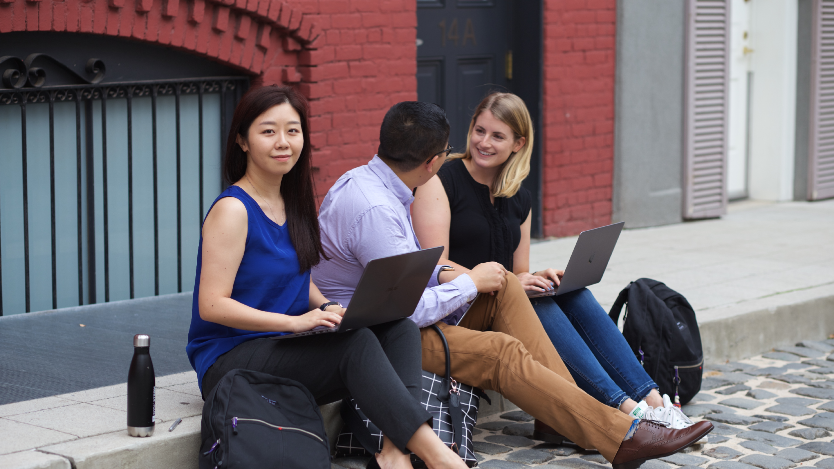 woman on curb with laptop