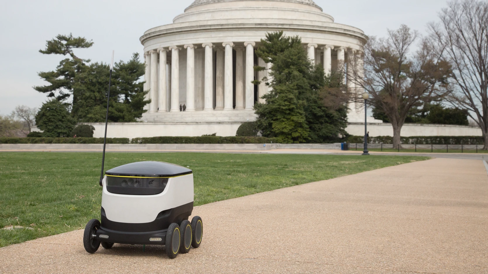 a small robot in front of a dc building beep boop
