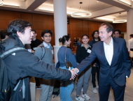 John Paulson (BS ’78) shakes hands with a student