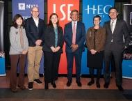 Six members of TRIUM leadership stand in front of banners with the TRIUM logo and logos from NYU Stern, LSE and HEC