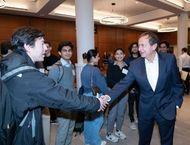 John Paulson shaking a student's hand