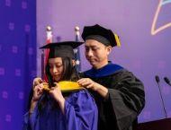 A student graduating and a faculty member
