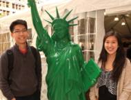 Students next to a replica of Statue of Liberty