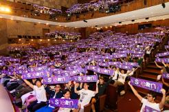 New undergraduate students holding up purple We Are Stern banners during orientation 